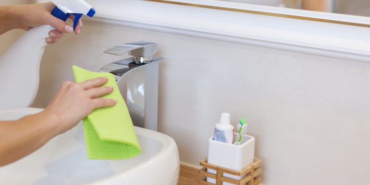 Blonde young woman cleaning bathroom